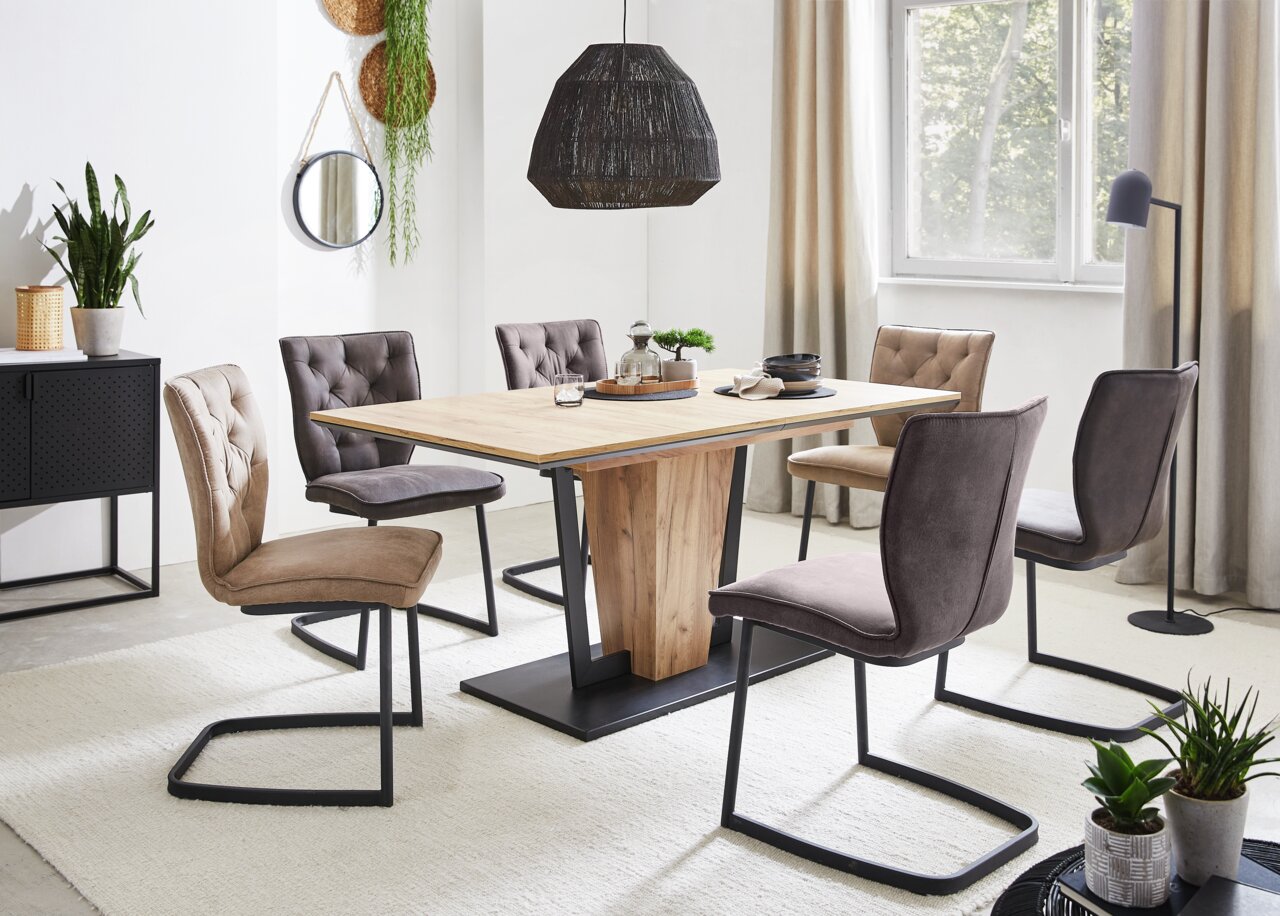 Esszimmer mit sechs Freischwinger-Stühlen um einen Holztisch, seitliche Perspektive