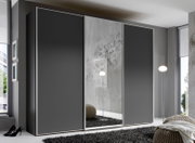 Moderner Schwebetürenschrank in dunklem Grau mit Spiegel in einem stilvollen Raum, seitliche Perspektive.