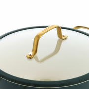 Nahaufnahme eines Topfdeckels mit goldfarbenem Griff und Glasoberfläche, seitliche Perspektive