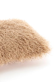 Nahaufnahme eines flauschigen, beigen Kissens mit lockiger Textur.