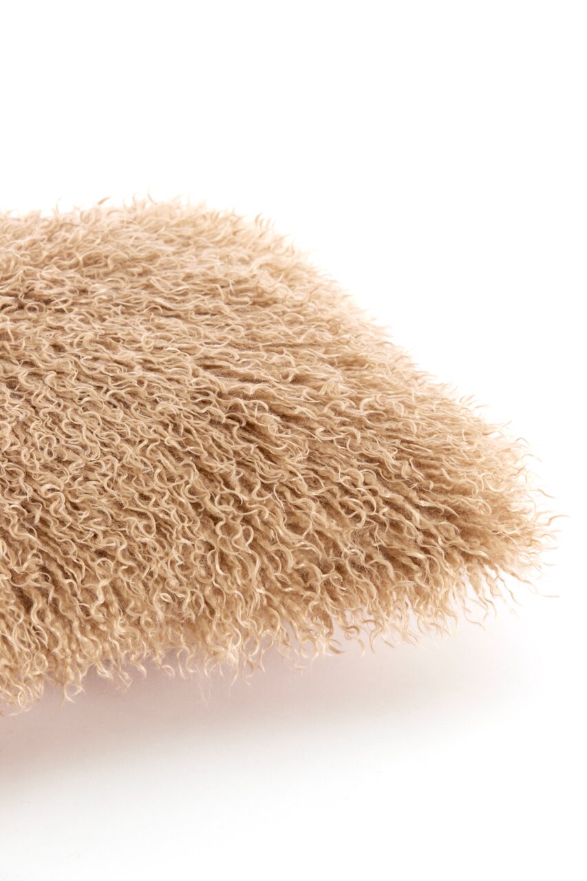 Nahaufnahme eines flauschigen, beigen Kissens mit lockiger Textur.
