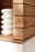 Nahaufnahme eines modernen Sideboards aus Holz mit klaren Linien und einem weißen Element, perspektivisch von der Seite aufgenommen.