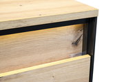 Detailansicht einer Nachtkommode aus hellem Holz mit schwarzem Rahmen, seitliche Perspektive