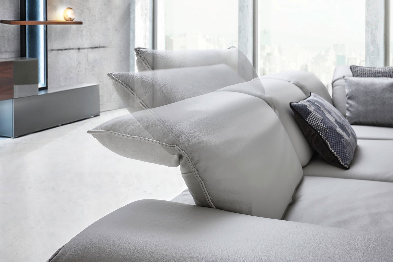 Detailansicht einer modernen Eckgarnitur mit verstellbaren Kopfstützen in einem hellen Raum.