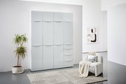 Moderner weißer Mehrzweckschrank mit Hochglanzoberfläche, frontal fotografiert, in einem stilvoll eingerichteten Raum mit Pflanze und Sessel.
