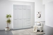 Moderner weißer Mehrzweckschrank mit Hochglanzoberfläche, frontal fotografiert, in einem stilvoll eingerichteten Raum mit Pflanze und Sessel.