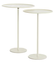 Zwei weiße Beistelltische mit runden Tischplatten und schlanken, hohen Beinen, seitliche Perspektive