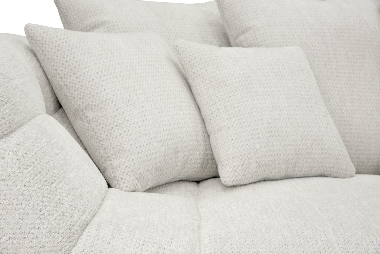 Nahaufnahme eines hellbeigen, weich gepolsterten Sofas mit strukturiertem Stoffbezug und mehreren Kissen, Perspektive: leicht von vorne/seitlich