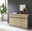 Modernes Sideboard aus Holz mit drei Schubladen und drei Türen, dekoriert mit Büchern, Kerzen und einer Skulptur, seitliche Perspektive.