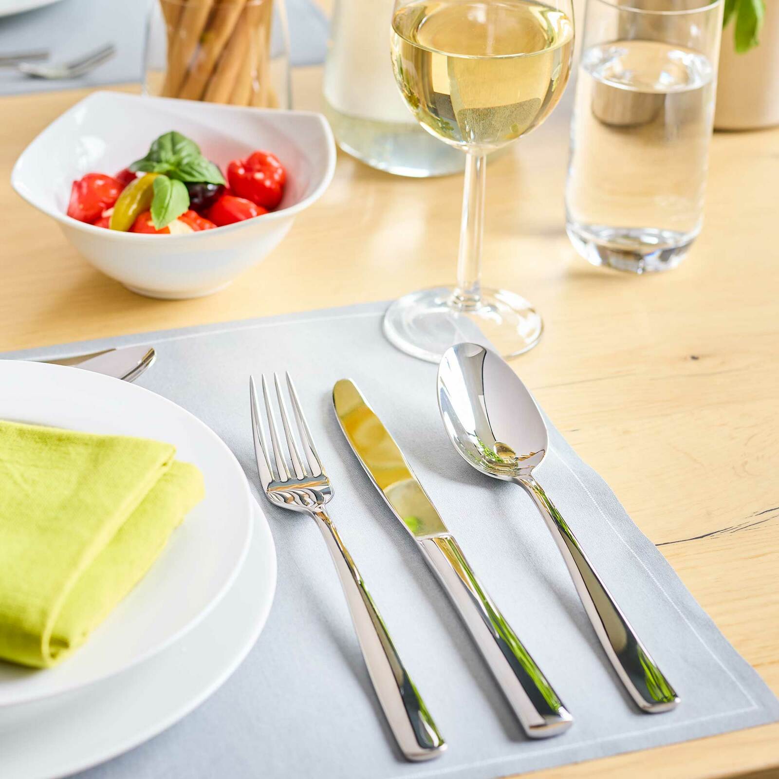 Rösle Besteckset 60-tlg. ELEGANCE Elegantes Besteckset auf einem gedeckten Tisch mit Teller, Serviette und Weinglas, aus der Vogelperspektive.