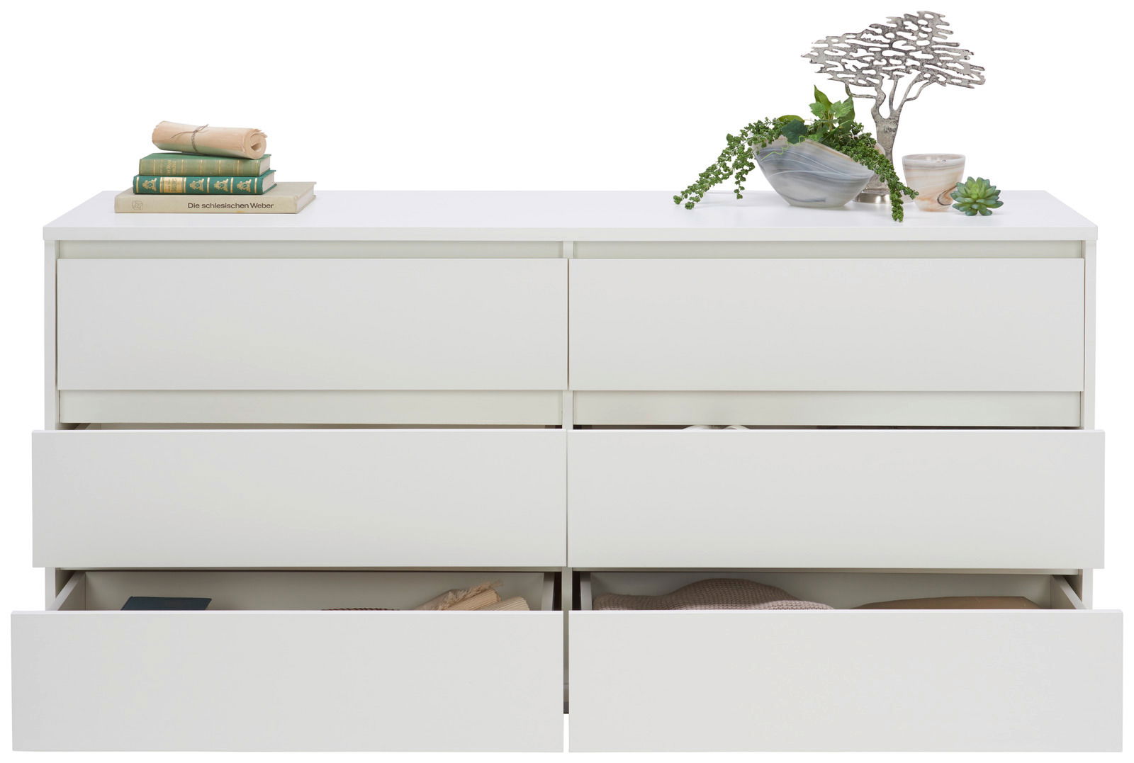 Frontale Ansicht eines weißen XL-Sideboards mit sechs Schubladen, teilweise geöffnet, dekoriert mit Büchern und Pflanzen.