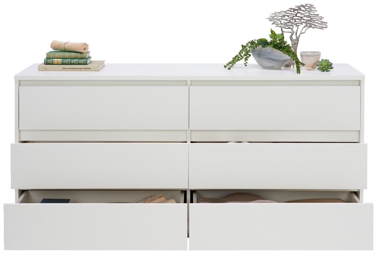 Frontale Ansicht eines weißen XL-Sideboards mit sechs Schubladen, teilweise geöffnet, dekoriert mit Büchern und Pflanzen.