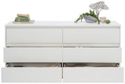 Frontale Ansicht eines weißen XL-Sideboards mit sechs Schubladen, teilweise geöffnet, dekoriert mit Büchern und Pflanzen.