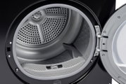 Innenansicht einer Frontlader-Wäschetrockner-Trommel aus Metall mit Flusensieb, Tür geöffnet; Perspektive: Nahaufnahme von vorne leicht seitlich.