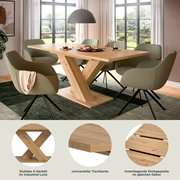 Moderner Esstisch mit stabilem X-Gestell im Industrial Look, ummantelter Tischkante und innenliegender Einlegeplatte, umgeben von stilvollen Stühlen in einem hellen Esszimmer mit Blick auf den Garten.