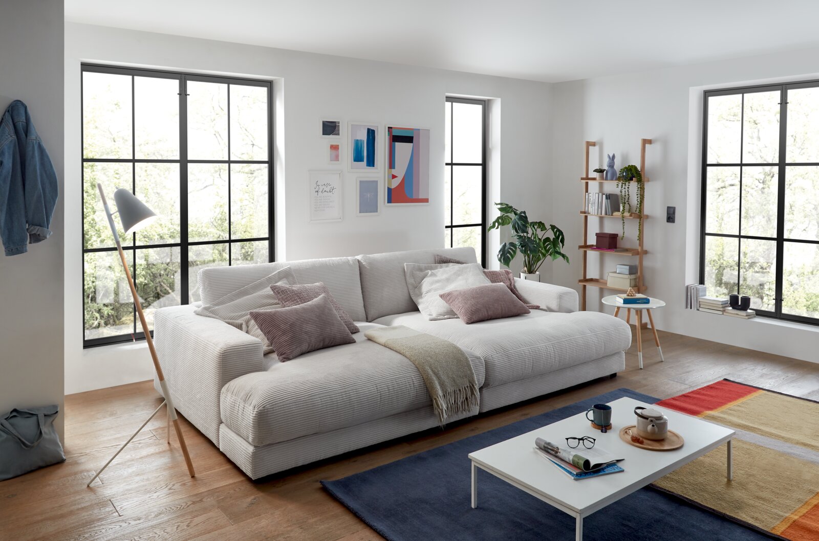 Großes, gemütliches Megasofa in einem modernen Wohnzimmer, seitliche Perspektive.