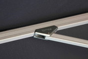 Nahaufnahme eines silbernen Metallrahmens mit der Aufschrift 'Knirps', Teil eines Pendelschirms.