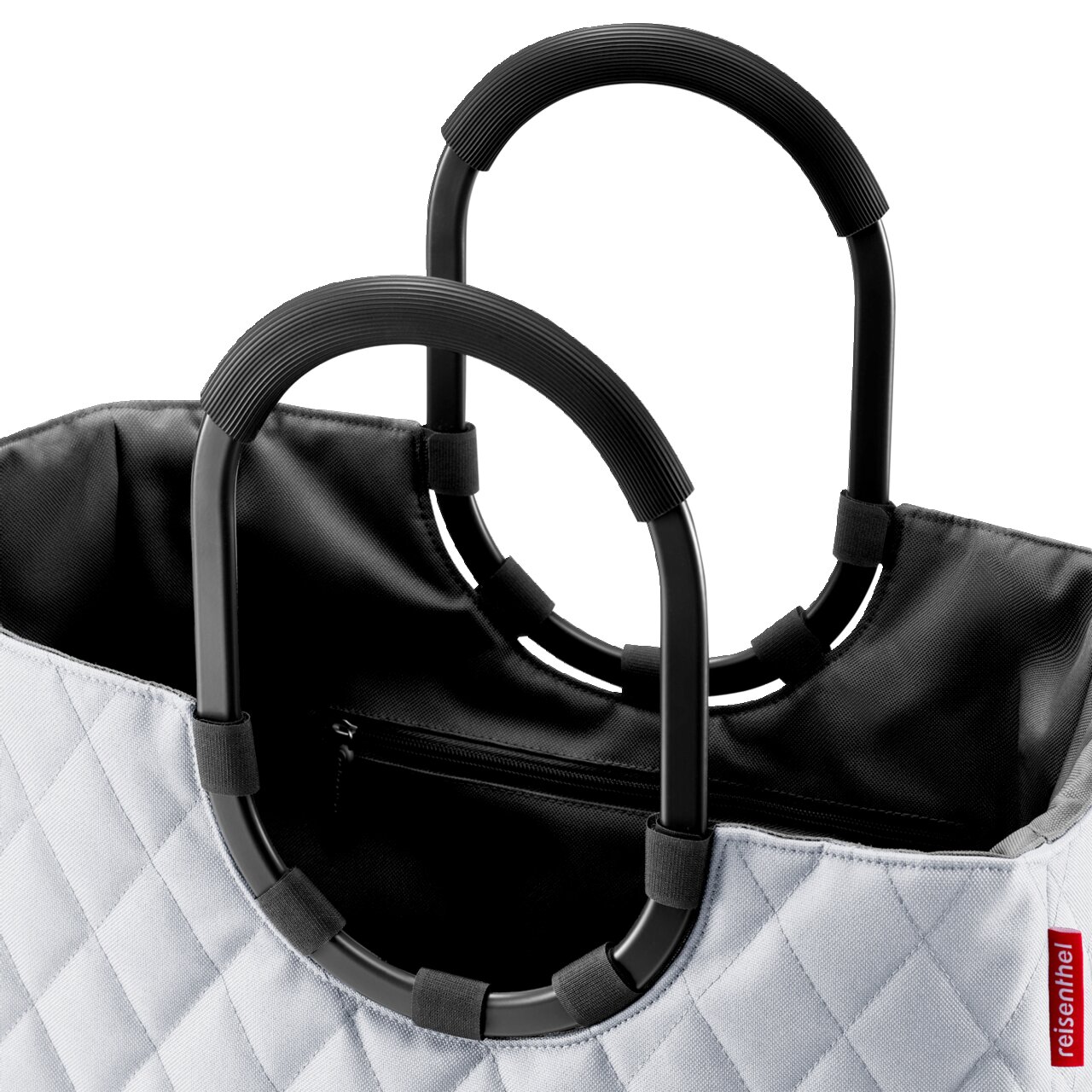 Nahaufnahme einer stilvollen Tasche mit schwarzem Innenfutter und zwei robusten, schwarzen Griffen. Die Außenseite zeigt ein elegantes Rautenmuster. Perspektive von oben.