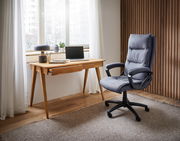 Moderner Schreibtisch aus Holz mit Laptop und Dekoration, seitliche Perspektive