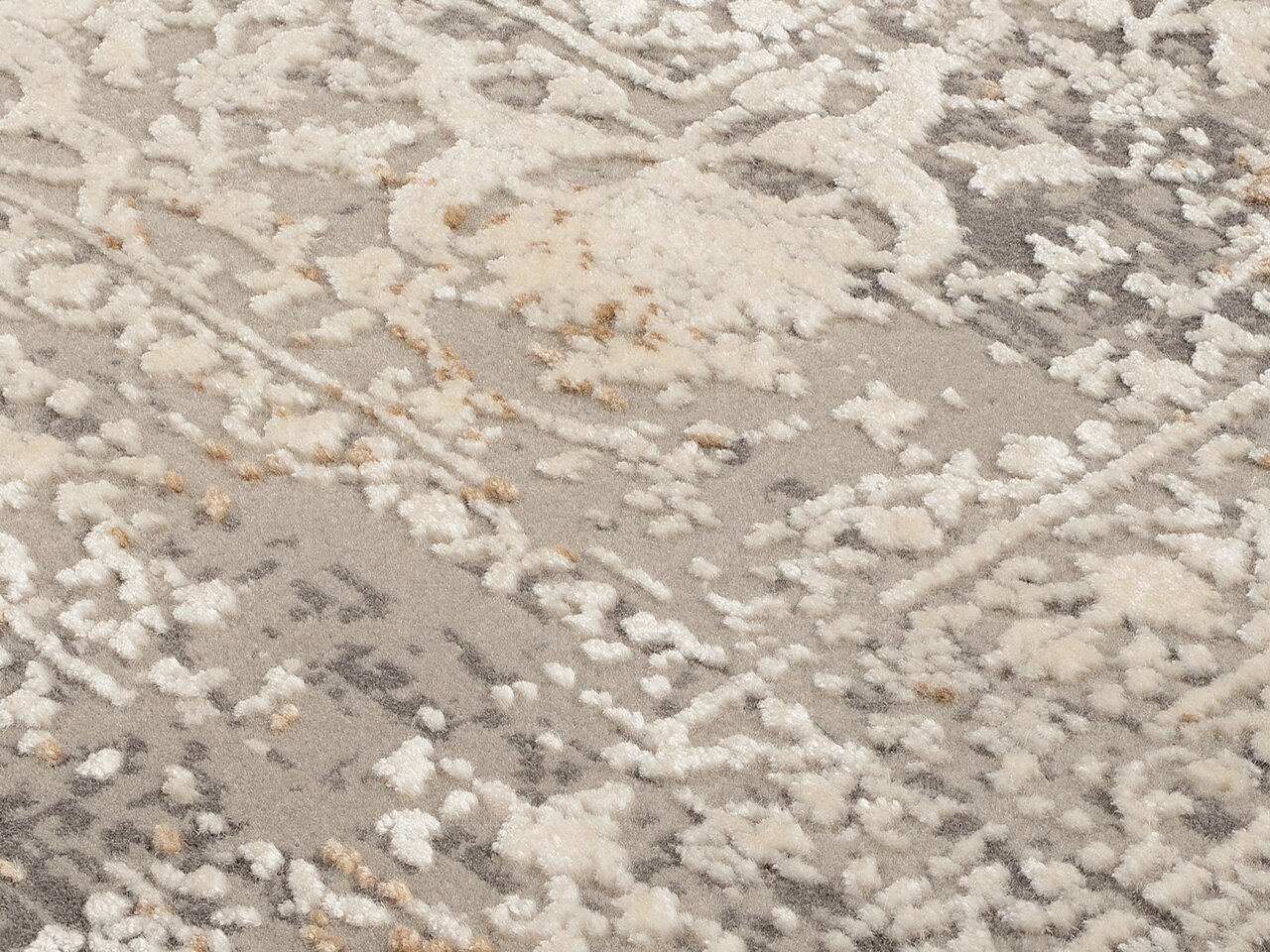 Nahaufnahme eines Designer-Teppichs mit cremefarbenem und grauem Muster, seitliche Perspektive