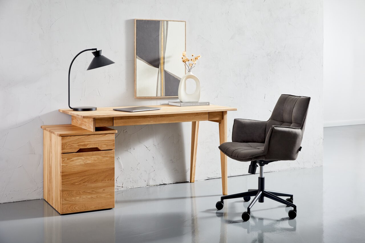 Moderner Drehsessel in dunklem Stoffbezug, seitliche Perspektive, neben einem Holztisch in einem minimalistischen Büro.
