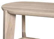 Nahaufnahme eines Sitzhockers aus hellem Holz mit abgerundeten Kanten, seitliche Perspektive.