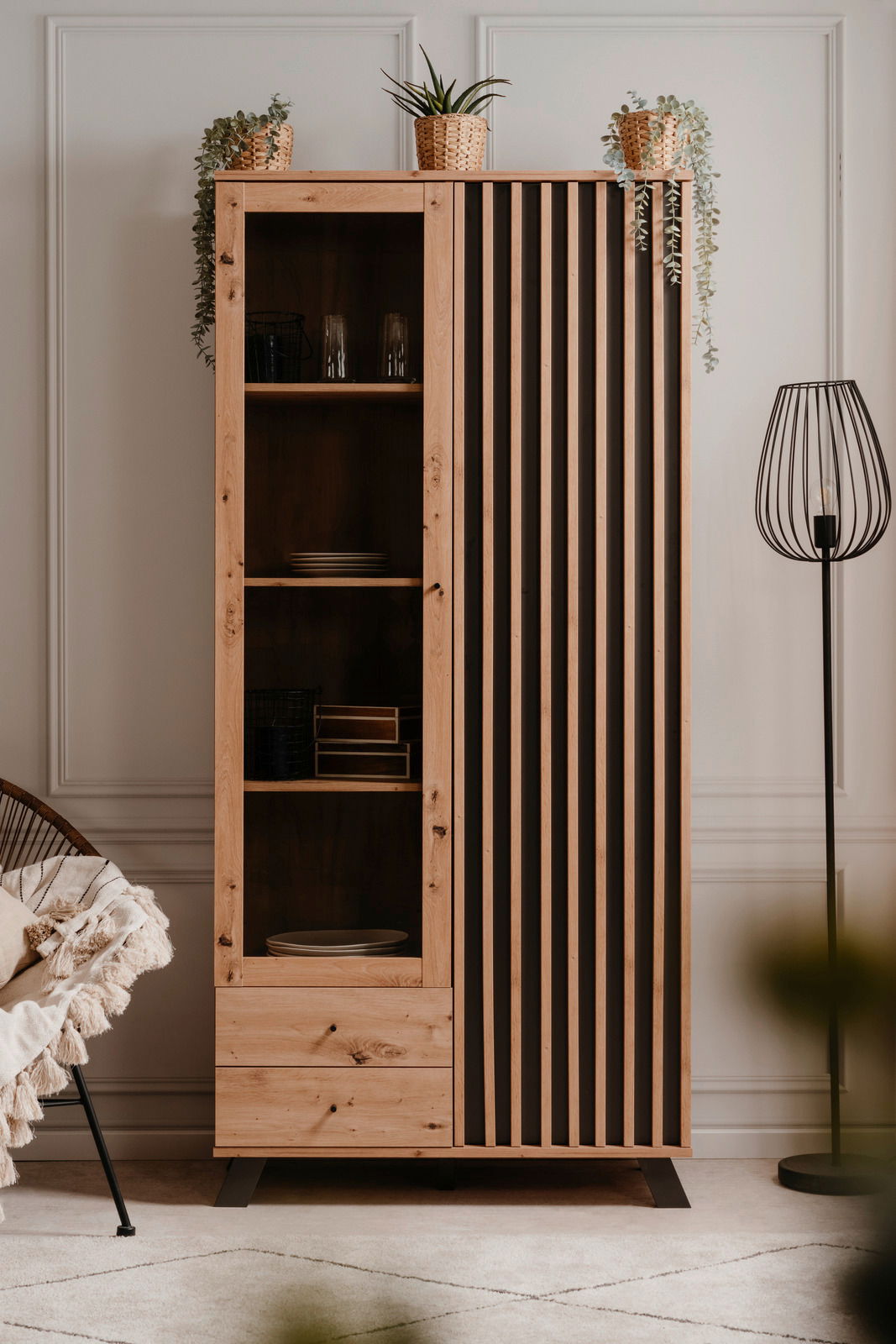 Moderne Vitrine aus Holz mit offenen Regalen und dekorativen Pflanzen, frontal fotografiert.