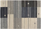 Frisé-Teppich mit geometrischem Muster in Grau- und Blautönen, aus der Vogelperspektive fotografiert.