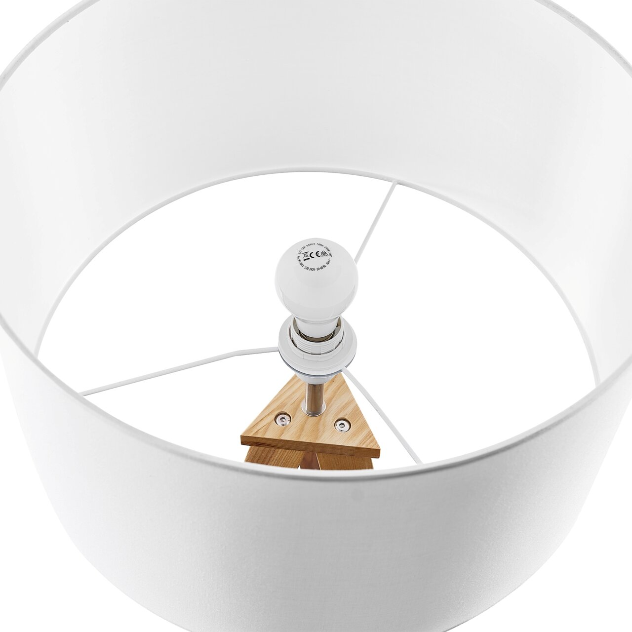 Blick von oben in einen weißen Lampenschirm einer Stehleuchte mit sichtbarer Glühbirne und Holzdetails.