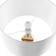 Blick von oben in einen weißen Lampenschirm einer Stehleuchte mit sichtbarer Glühbirne und Holzdetails.