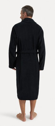 Rückansicht eines schwarzen Bademantels mit Schalkragen, getragen von einer Person. Der Bademantel hat einen Gürtel und reicht bis zu den Waden.