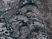 Nahaufnahme eines grauen Teppichs mit blauen und weißen Akzenten, perspektivisch von der Seite aufgenommen.