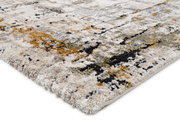 Nahaufnahme eines Designer-Teppichs mit abstraktem Muster in Beige, Grau, Schwarz und Orange. Perspektive von der Seite.