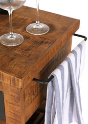 Nahaufnahme eines rustikalen Servierwagens aus Holz mit zwei Weingläsern und einem Handtuch an der Seite, von oben betrachtet.