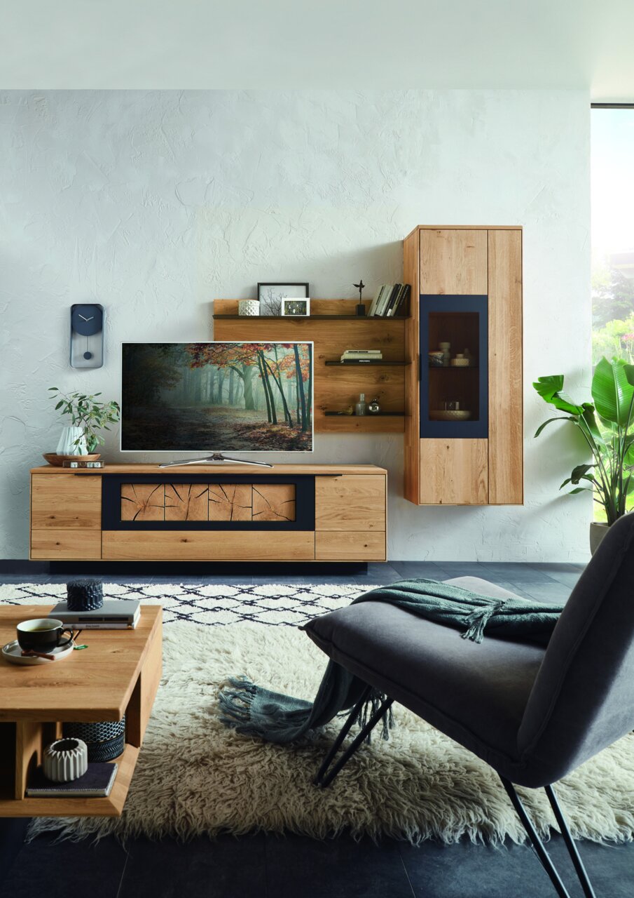 Moderne wandcombinatie van hout met tv-kast, planken en vitrinekast, gefotografeerd vanaf de voorkant in een stijlvol ingerichte woonkamer.