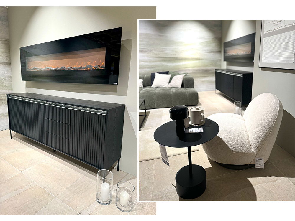 Einladendes Wohnzimmer mit einer großen Eckcouch und einem gemütlichen Sessel. Der elektrische Kamin sorgt für eine warme Atmosphäre.