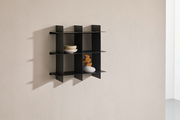 Schwarzes Wandregal mit mehreren Fächern, seitliche Perspektive, dekoriert mit Schalen und einer Vase.