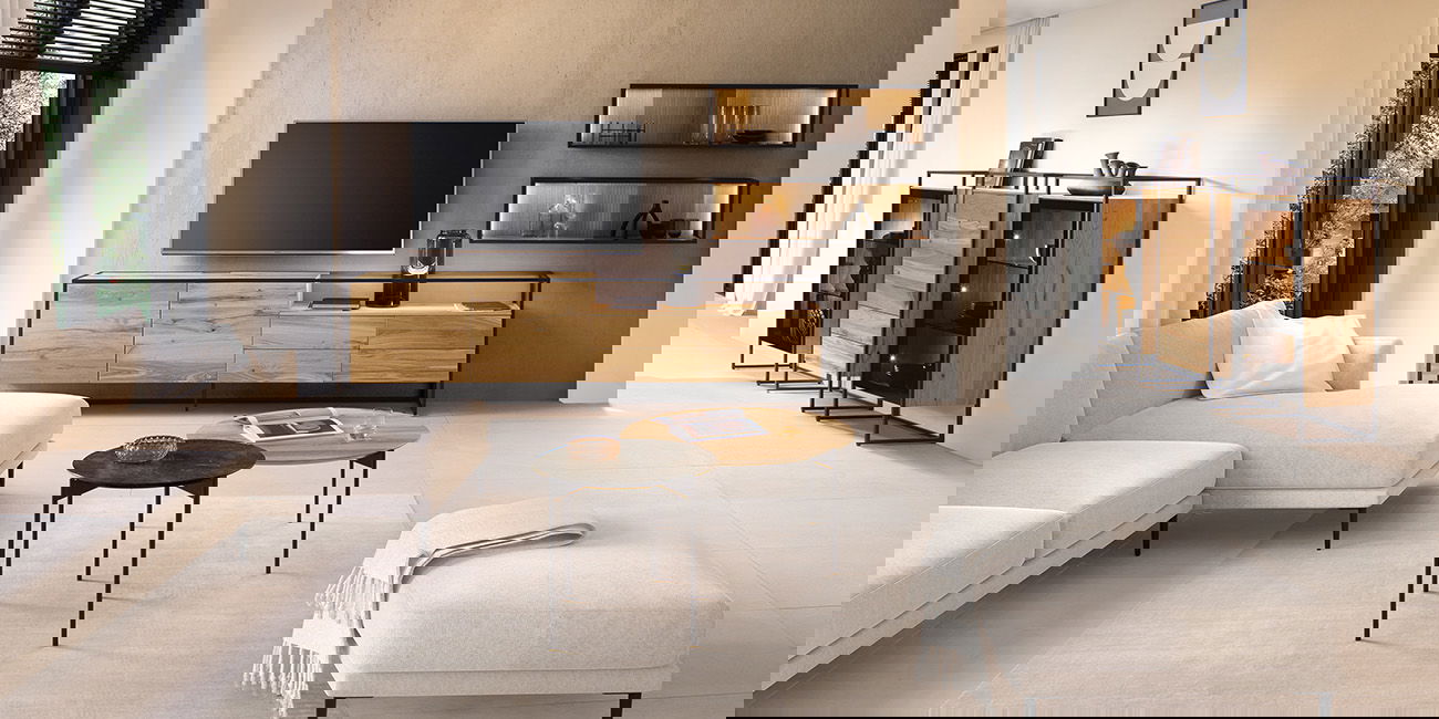 Ein helles Wohnzimmer mit Holz- und Metallmöbeln, beigem Sofa und stilvoller Dekoration.