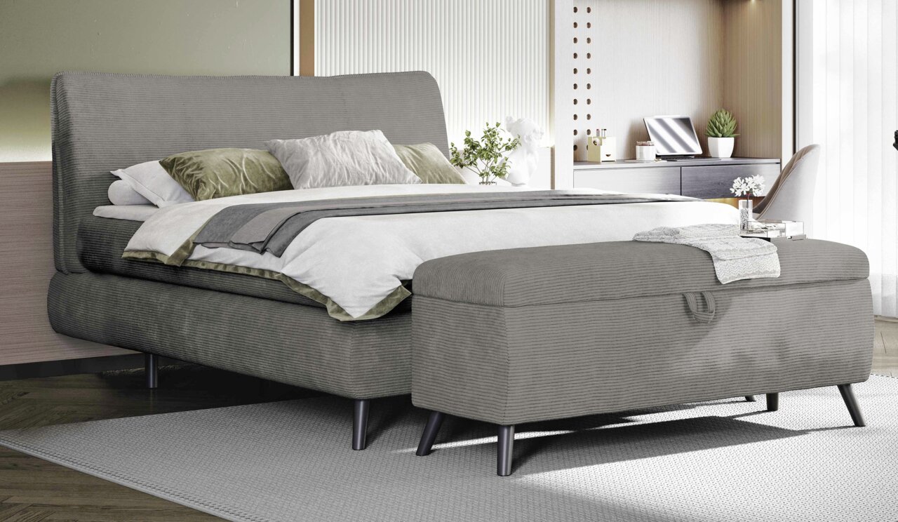 Graues Boxspringbett 180x200 mit Bettbank im Vordergrund, seitliche Perspektive