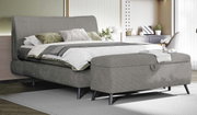 Graues Boxspringbett 180x200 mit Bettbank im Vordergrund, seitliche Perspektive