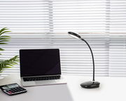 LED-Schreibtischleuchte auf einem Schreibtisch neben einem Laptop und einem Taschenrechner, seitliche Perspektive