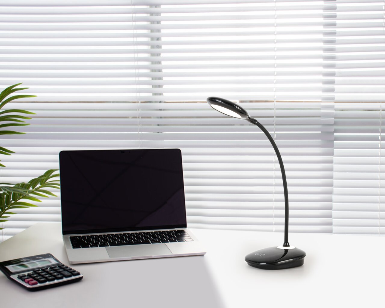 LED-Schreibtischleuchte auf einem Schreibtisch neben einem Laptop und einem Taschenrechner, seitliche Perspektive
