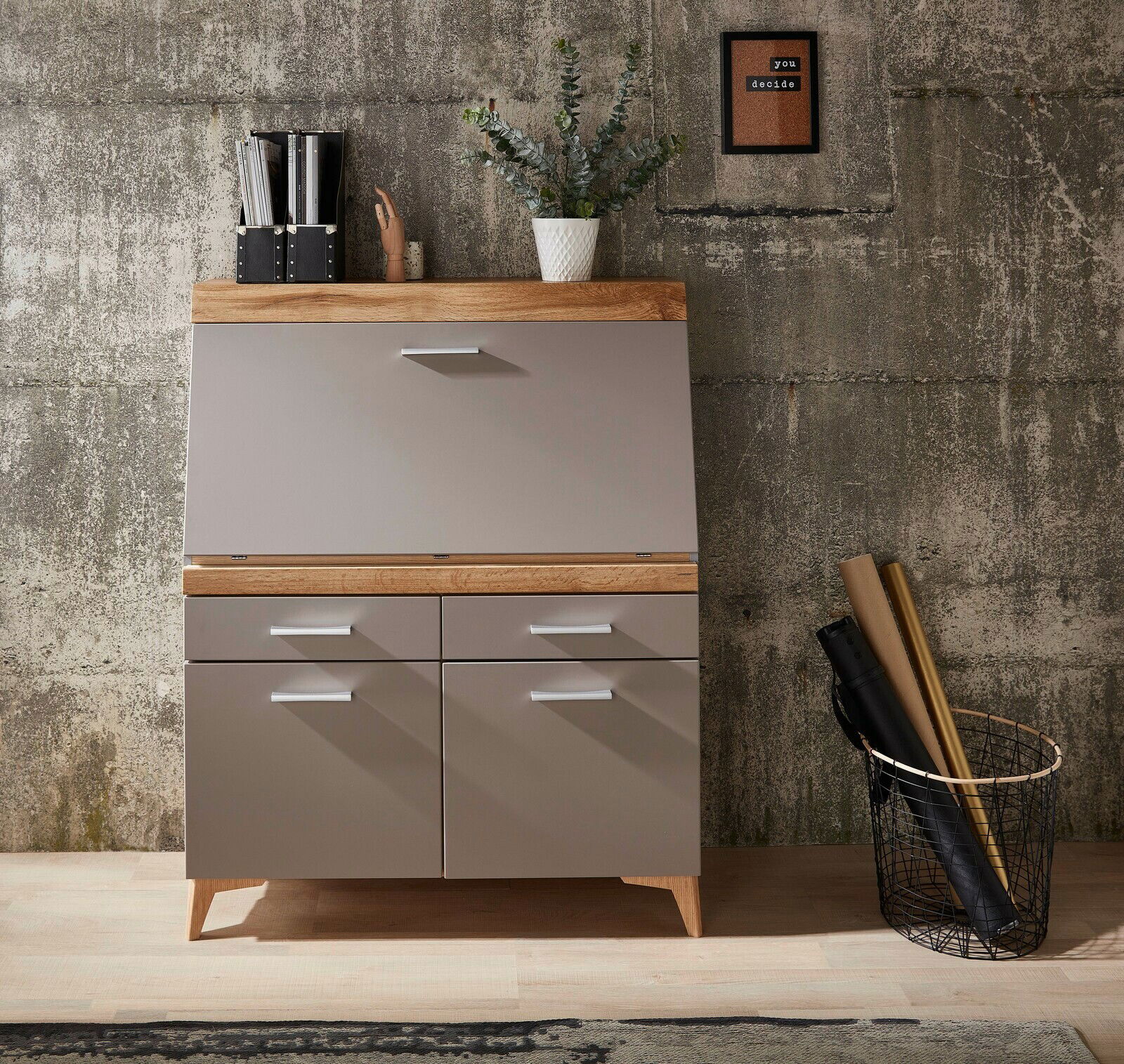 Moderner Sekretär aus Holz und Metall mit Schubladen und Klappe, frontal fotografiert, dekoriert mit Pflanzen und Büromaterial.