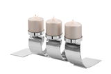 Moderner dreiflammiger Kerzenhalter aus glänzendem Metall mit drei brennenden Kerzen, seitliche Perspektive.