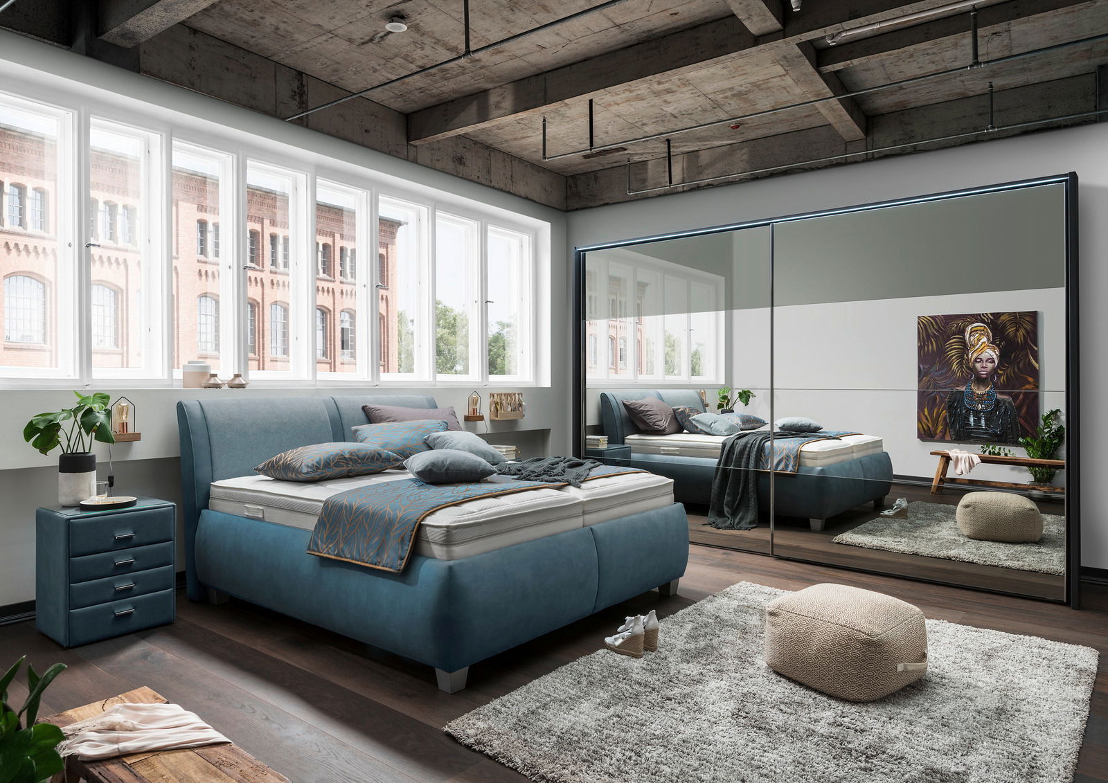 Modernes Polsterbett in einem stilvollen Schlafzimmer mit großen Fenstern und einem Spiegel, der den Raum reflektiert. Perspektive von der Seite.