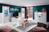 Helles Wohnzimmer mit einem Highboard in weißem Holzdesign, dekoriert mit Pflanzen und Vasen, seitliche Perspektive.