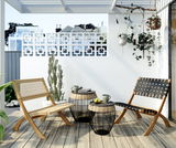 Zwei Beistelltische mit Korbdesign und Glasplatte auf einer Terrasse, umgeben von zwei Stühlen und Pflanzen, aus einer seitlichen Perspektive fotografiert.