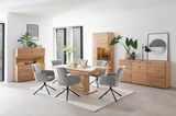 Modernes Wohnzimmer mit einem Sideboard aus Holz, umgeben von stilvollen grauen Stühlen und einem Holztisch, aus der Perspektive des Raumes betrachtet.