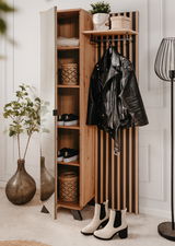 Garderobe aus Holz mit Spiegel, Regalen und Haken, frontal fotografiert. Dekoriert mit Pflanzen, Körben und Kleidung.