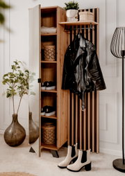 Garderobe aus Holz mit Spiegel, Regalen und Haken, frontal fotografiert. Dekoriert mit Pflanzen, Körben und Kleidung.